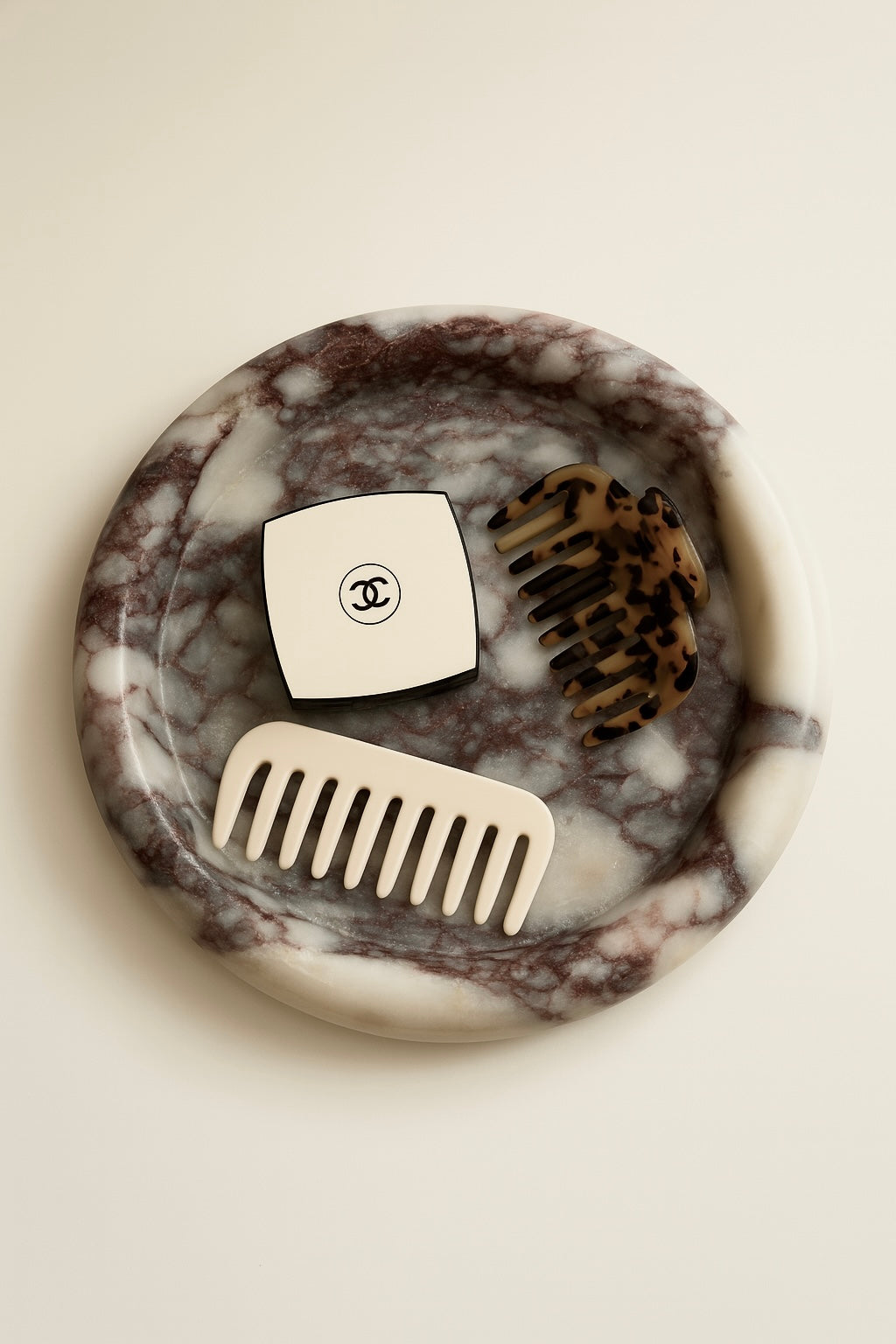 Marble-patterned coaster with two combs on a cream background