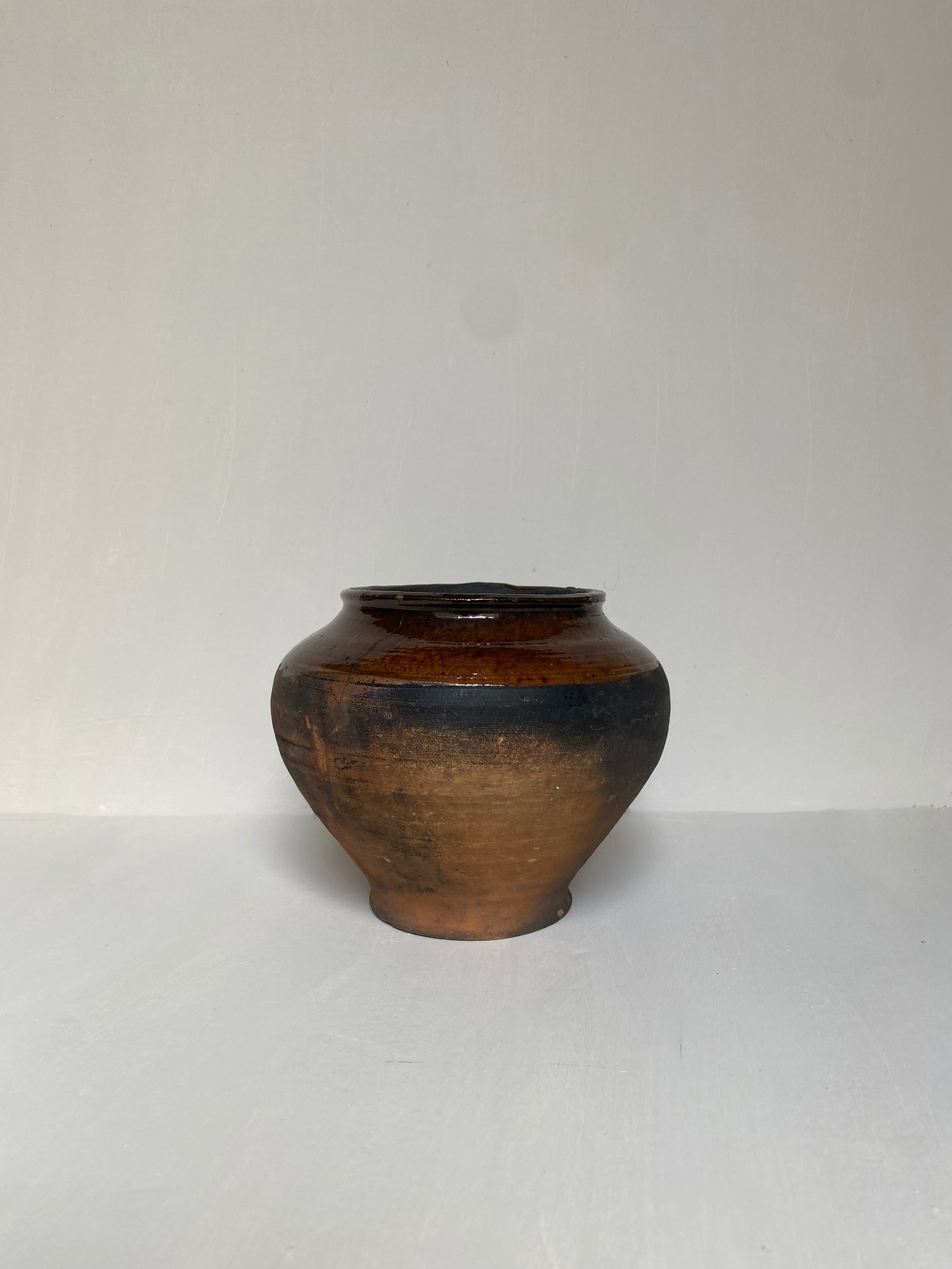 A small brown clay pot on a white background