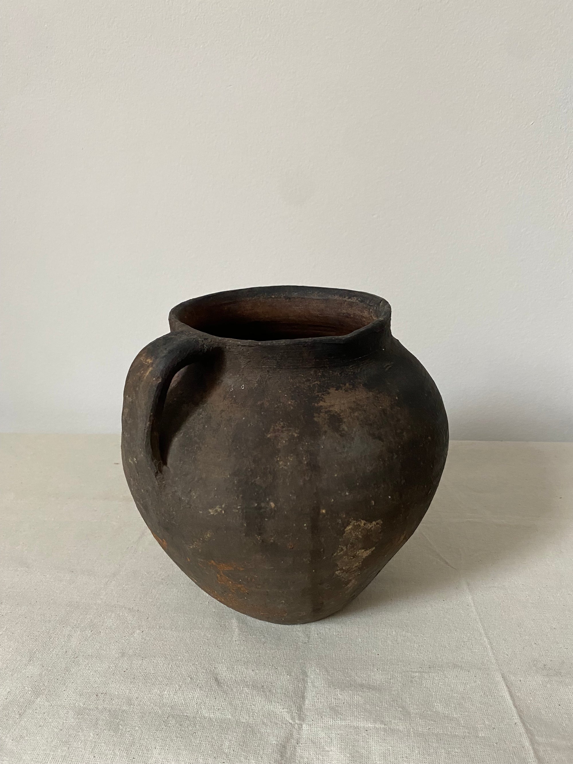 Black ceramic pot on a light gray background