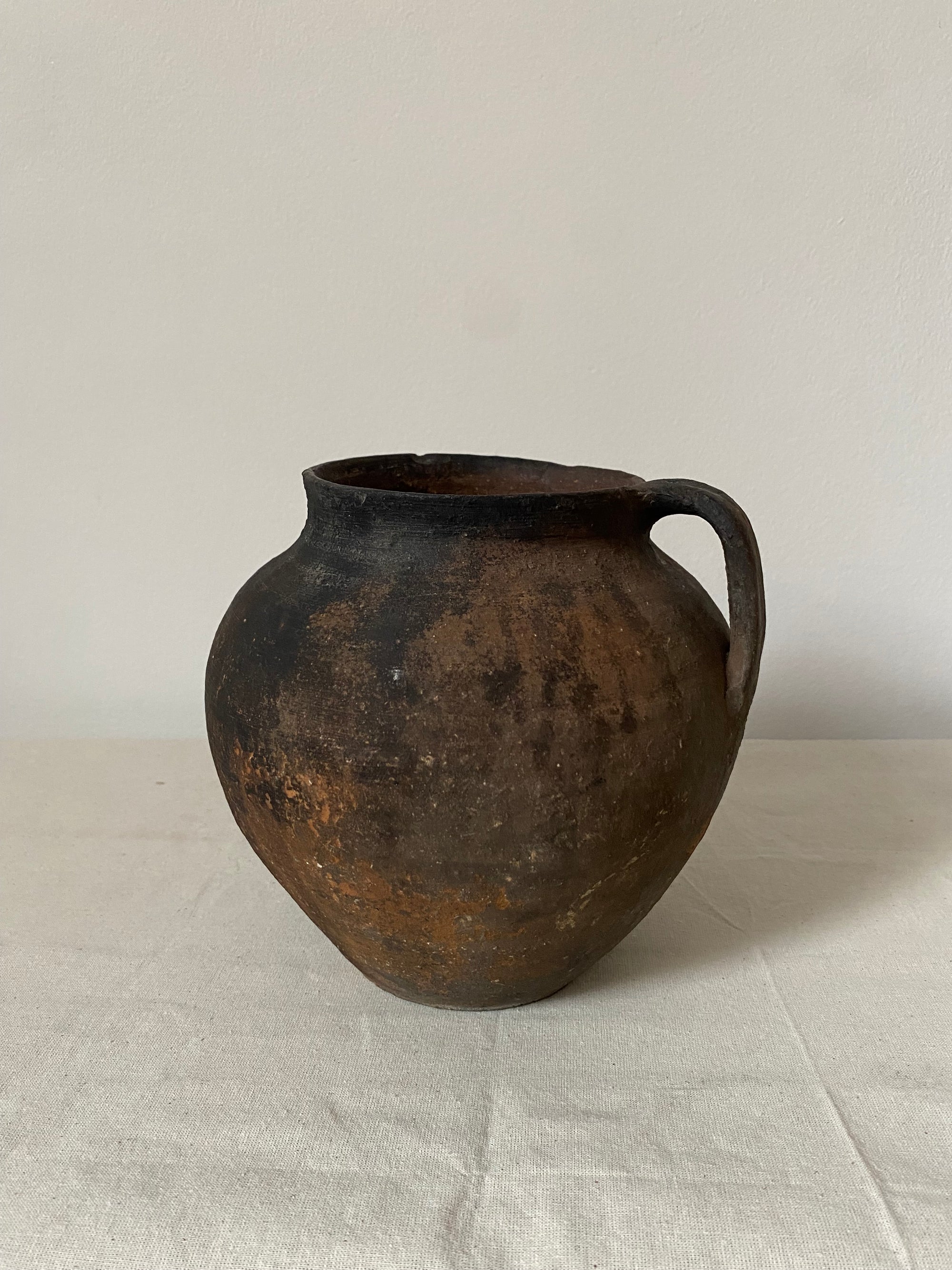 Black ceramic pot on a light gray background