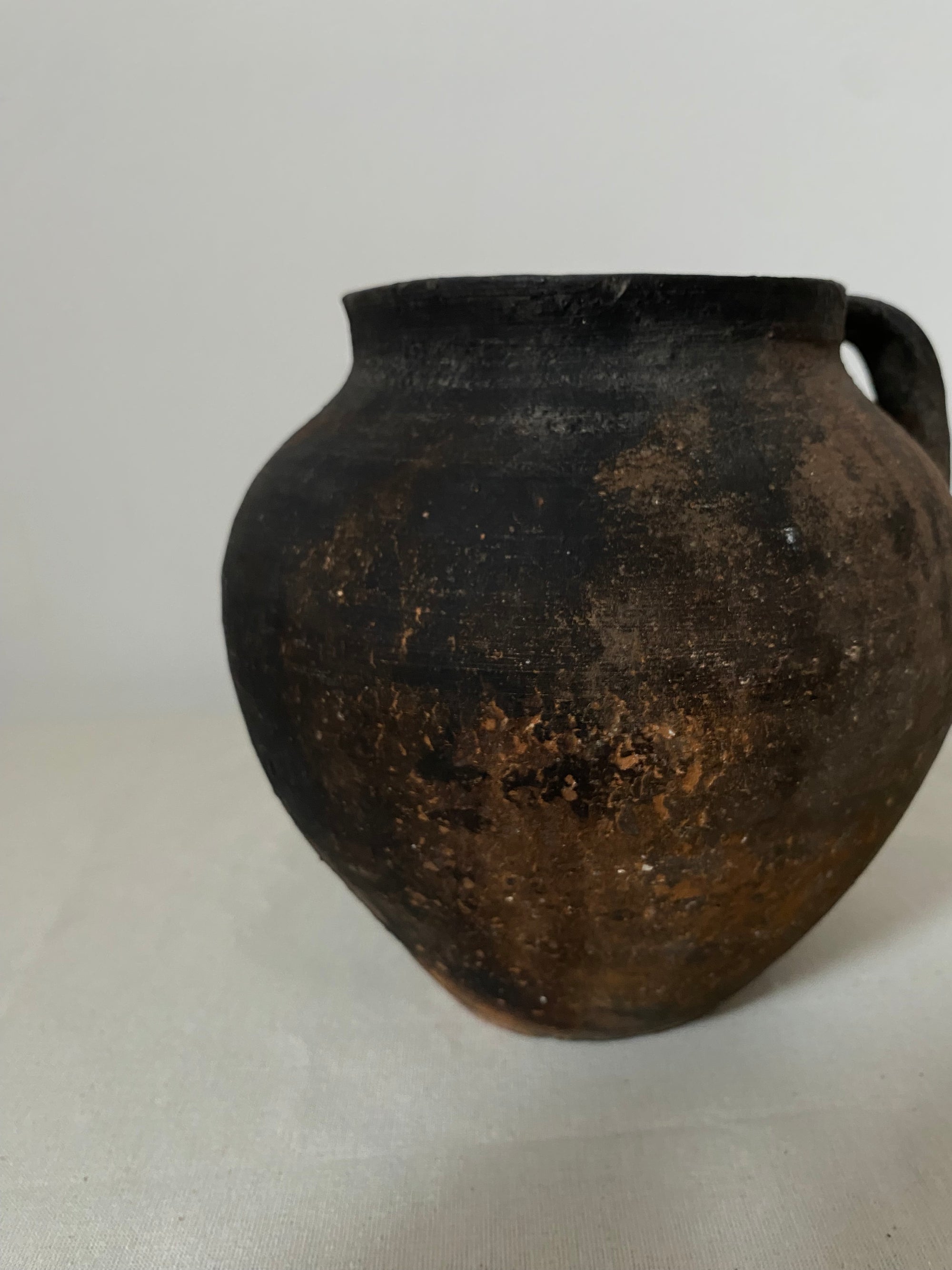 Black ceramic pot on a white background