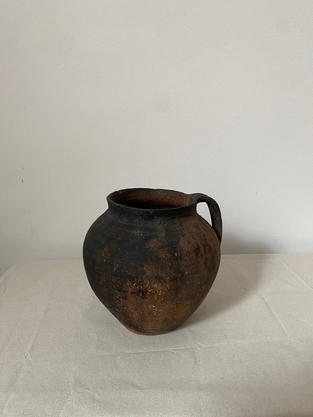 Rustic black pot on a light gray background