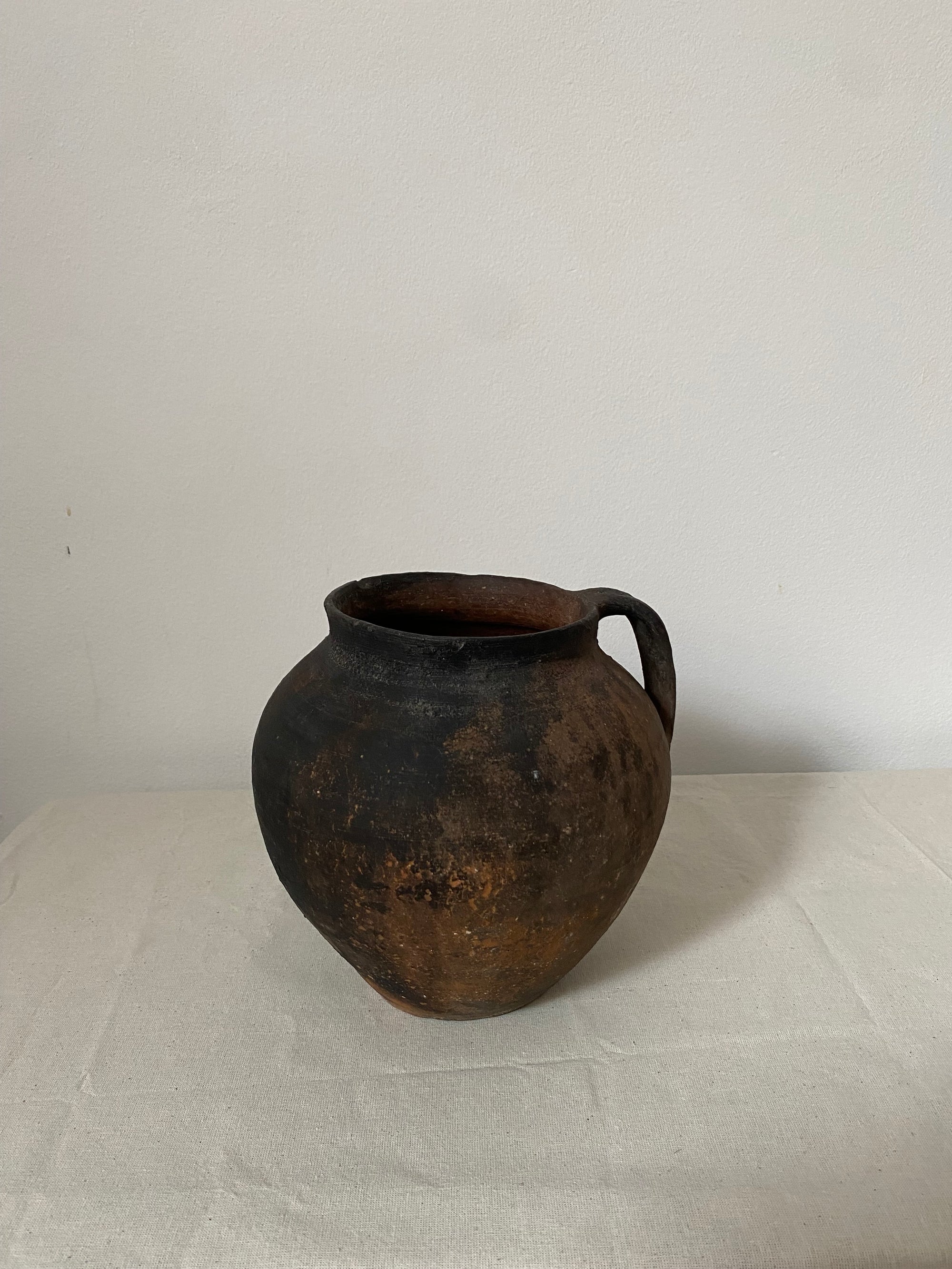 Rustic black pot on a light gray background