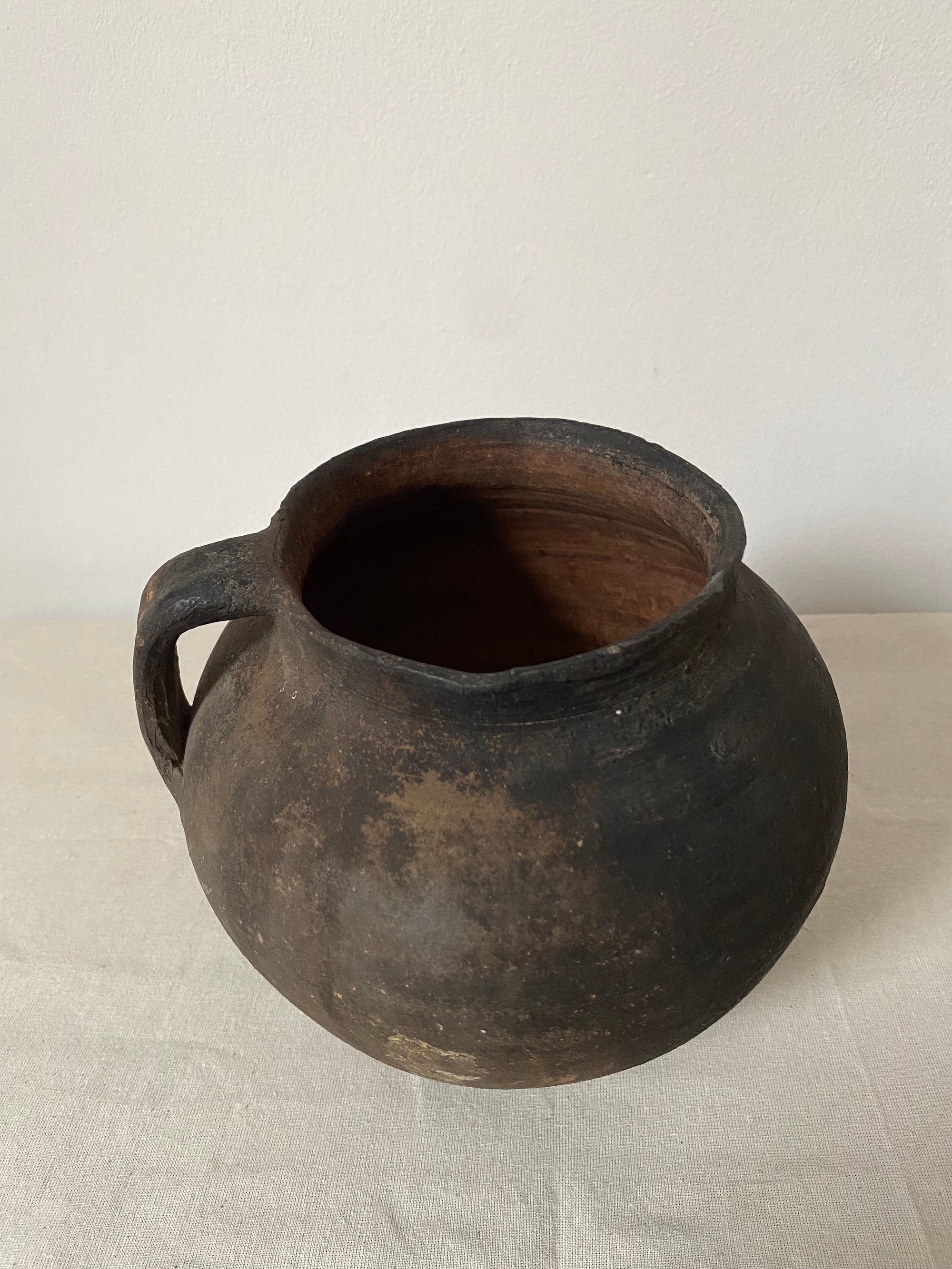 Black ceramic jar on a light gray background
