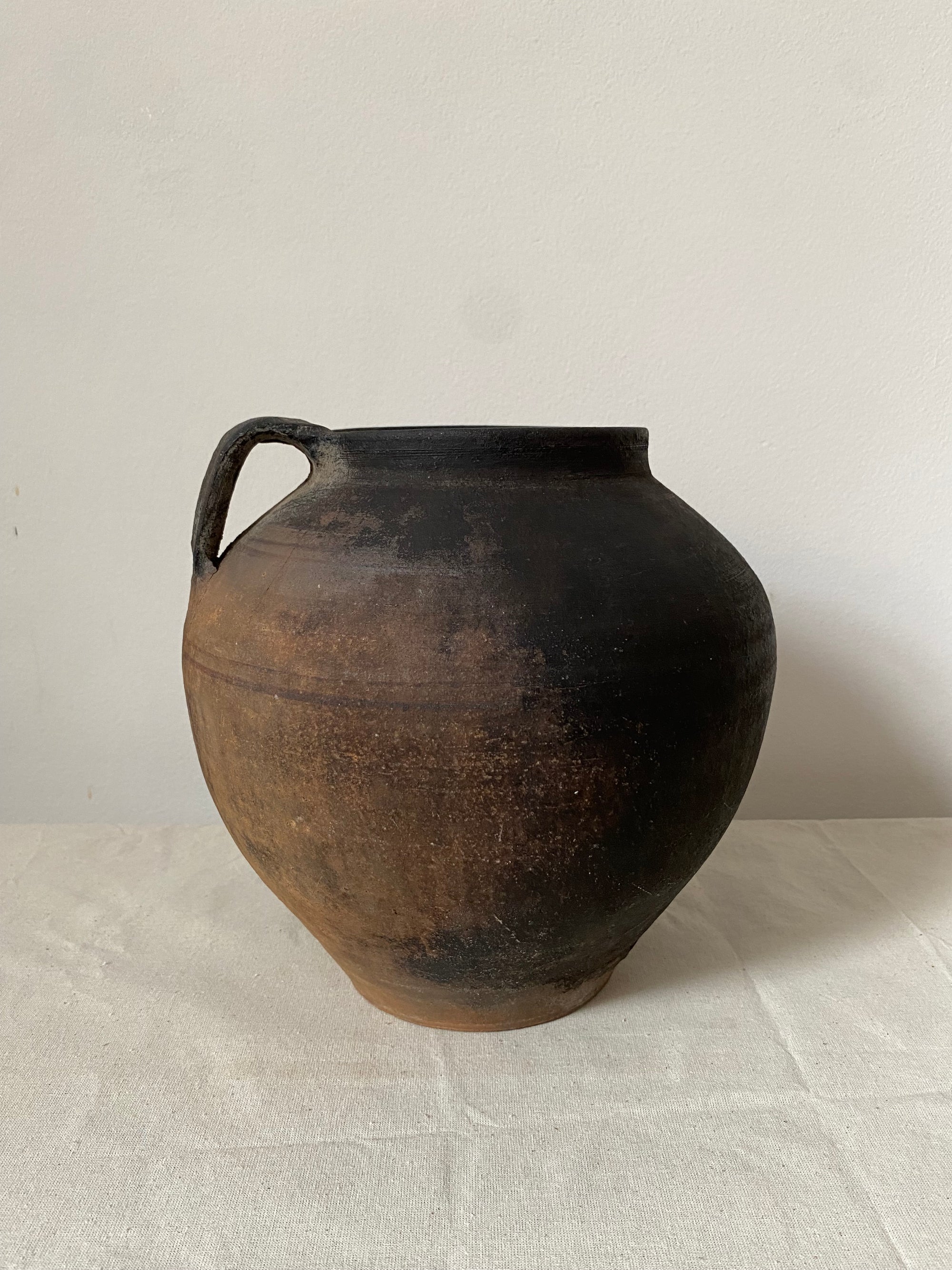 Black ceramic vase on a light grey surface
