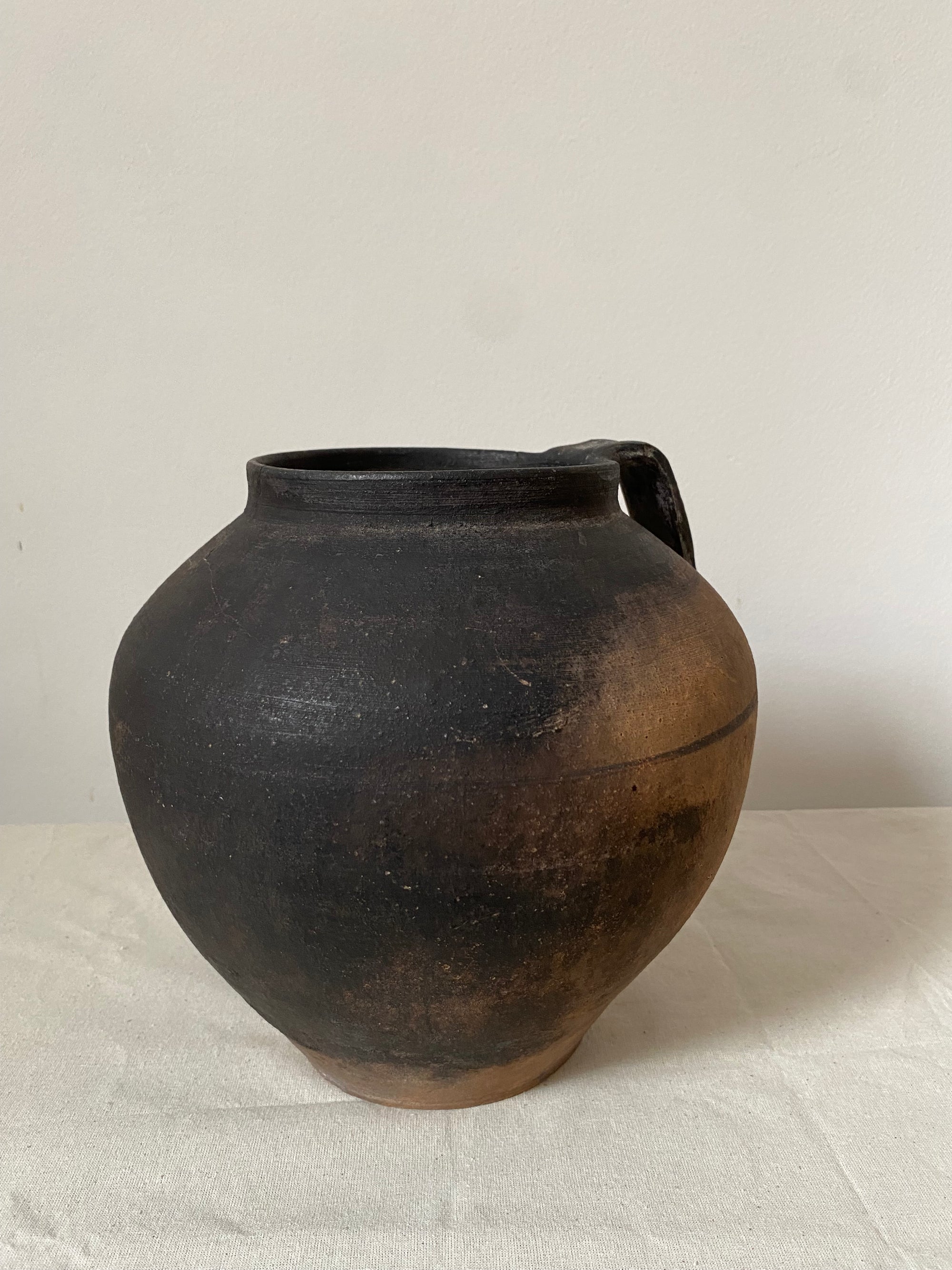 Black ceramic vase on a light gray background